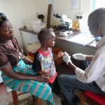 LAB mnager takes malaria sample from child